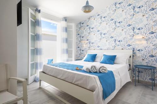 a bedroom with a bed with blue and white wallpaper at I Gufi Bed & Breakfast Marzamemi in Marzamemi