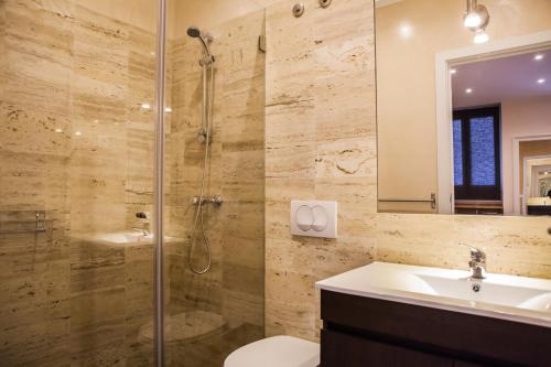 y baño con ducha, aseo y lavamanos. en Rossio Suites, en Lisboa