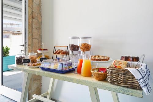 a table with breakfast foods and drinks on it at I Gufi Bed & Breakfast Marzamemi in Marzamemi