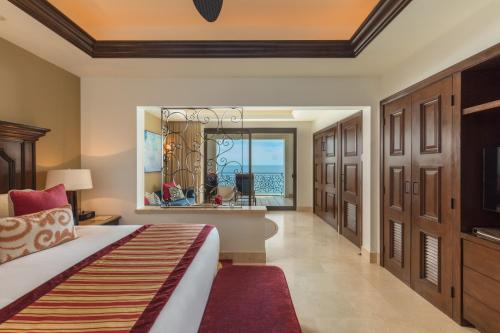 Grand Solmar Land's End Resort & Spa في كابو سان لوكاس: غرفة نوم مع سرير وإطلالة على المحيط