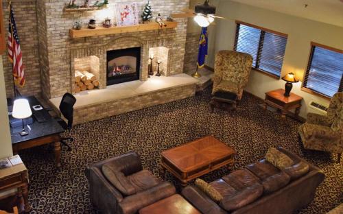 a living room with a fireplace and couches at AmericInn by Wyndham Merrill in Merrill