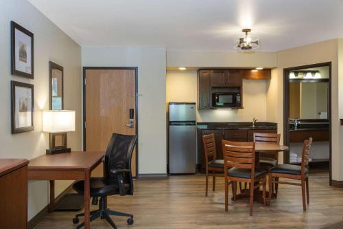 a kitchen and dining room with a table and chairs at AmericInn by Wyndham Merrill in Merrill