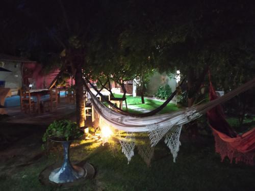 a hammock hanging from a tree in a yard at night at Pousada A Vida é Bela in Águas Belas
