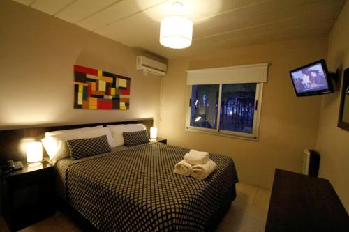 Un dormitorio con una cama con una toalla. en La Pedrera, en Pinamar