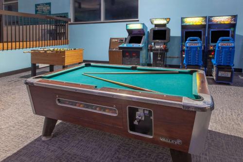 a pool table in a room with arcade machines at Days Inn & Suites by Wyndham Grand Rapids Near Downtown in Grand Rapids