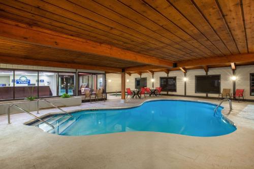 a swimming pool in a building with a wooden ceiling at Days Inn & Suites by Wyndham Wisconsin Dells in Wisconsin Dells