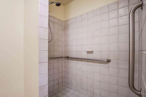 a bathroom with a shower with white tiles at Baymont by Wyndham Yakima Riverfront in Yakima