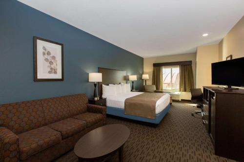 a hotel room with a bed and a couch at AmericInn by Wyndham Sioux Falls North in Sioux Falls