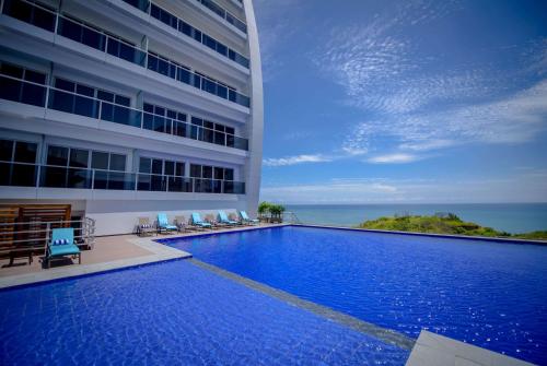 a swimming pool in front of a building at Wyndham Manta Sail Plaza Hotel and Convention Center in Manta