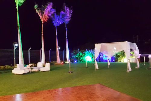 an outdoor event with a tent and palm trees at night at Wyndham Manta Sail Plaza Hotel and Convention Center in Manta