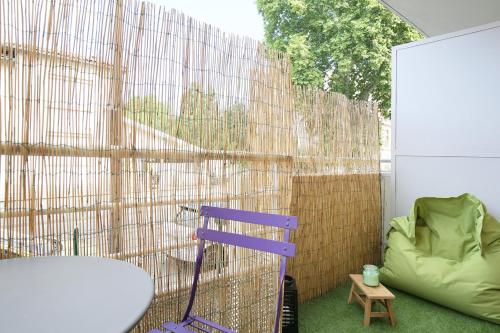 a purple chair sitting in front of a fence at expat renting - Le Sophia - Casino Barrière - Parking in Toulouse