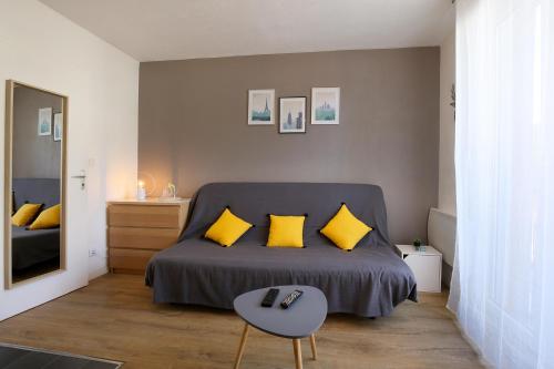 - une chambre avec un lit doté d'oreillers jaunes et d'une table dans l'établissement expat renting - Le Sophia - Casino Barrière - Parking, à Toulouse