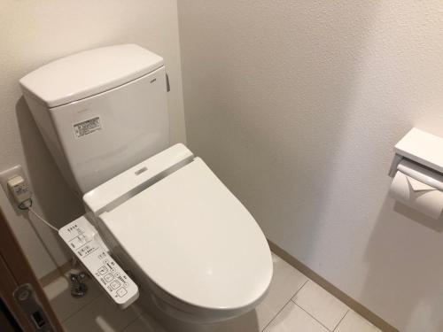 a bathroom with a white toilet in a stall at BiBi Hotel Conventionbay in Ginowan