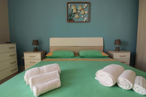 a bedroom with a bed with towels on it at Sabbia e Mare in Torre San Giovanni Ugento