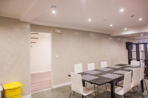 una sala da pranzo con tavolo nero e sedie bianche di Rossio Suites a Lisbona