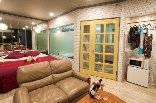uma sala de estar com um sofá e uma cama em Hotel JuJu em Kurume