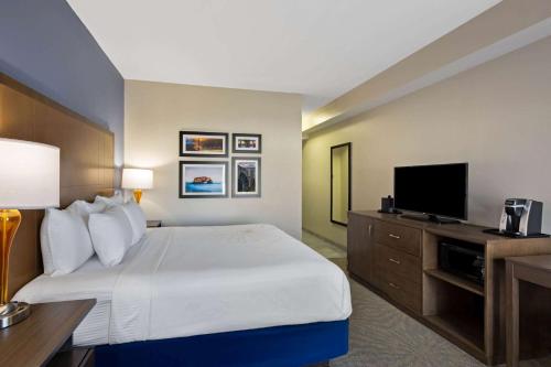 a hotel room with a bed and a flat screen tv at La Quinta by Wyndham Morgan Hill-San Jose South in Morgan Hill