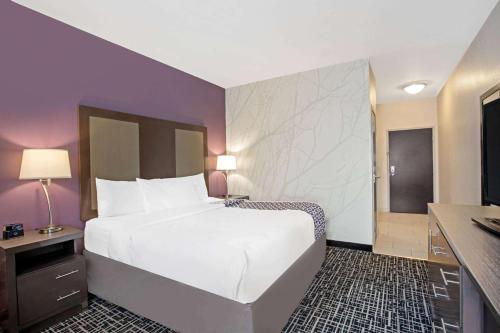a bedroom with a large white bed and purple walls at La Quinta by Wyndham York in York