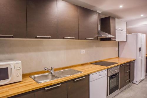 una cucina con lavello e microonde di Rossio Suites a Lisbona