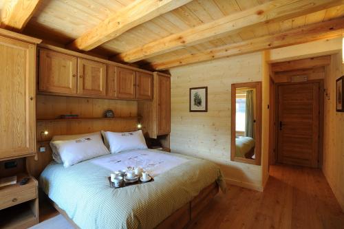 コー​​ニュにあるHIBOU chambres & spa - Cogneの木造キャビン内のベッド1台が備わるベッドルーム1室を利用します。