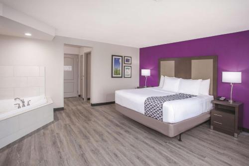 a hotel room with a large bed and a bath tub at La Quinta by Wyndham Effingham in Effingham