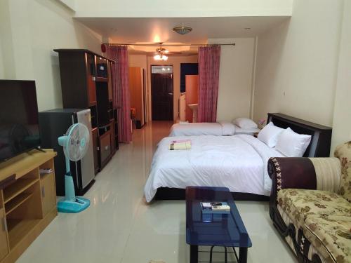 a hotel room with a bed and a tv and a couch at โฮมสเตย์ เมืองไทยฟิตเนส อารีนา in Ban Bo Nam