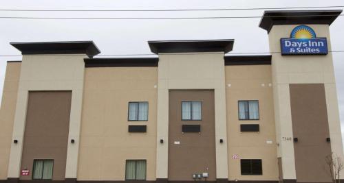 a building with a sign on top of it at Days Inn & Suites by Wyndham Port Arthur in Port Arthur