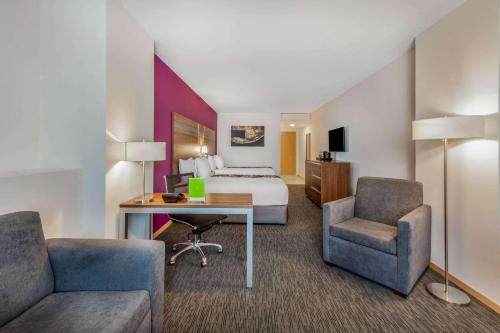 a hotel room with a bed and a desk and chairs at La Quinta by Wyndham San Jose Chiapa Puebla in San José Chiapa