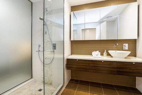 La salle de bains est pourvue d'un lavabo et d'une douche. dans l'établissement Darwin Waterfront Luxury Suites, à Darwin