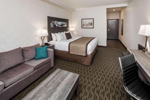 a hotel room with a bed and a couch at Ramada by Wyndham Revelstoke in Revelstoke