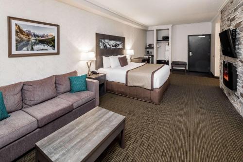 a large hotel room with a bed and a couch at Ramada by Wyndham Revelstoke in Revelstoke
