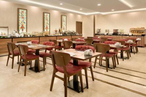 a restaurant with wooden tables and red chairs at Ramada by Wyndham Yalova in Yalova