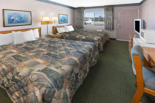 A bed or beds in a room at Days Inn by Wyndham Oroville