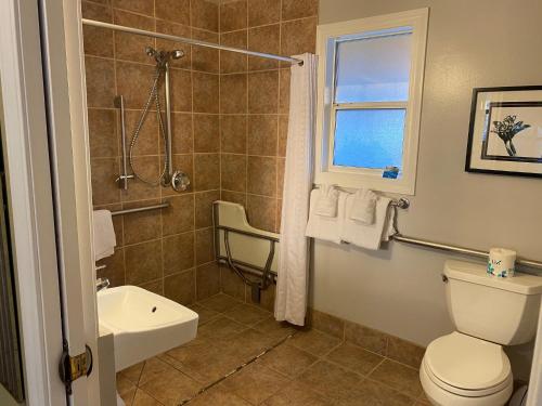 uma casa de banho com um chuveiro, um WC e um lavatório. em Sea Breeze Inn - Pacific Grove em Pacific Grove