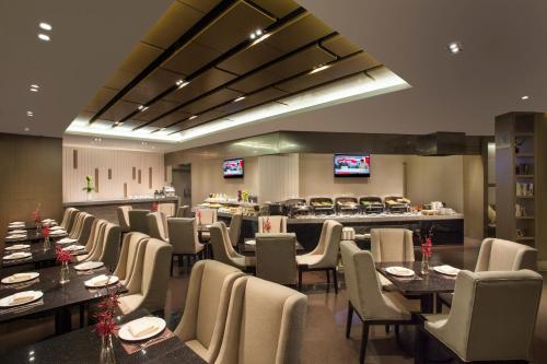 a restaurant with tables and chairs and a bar at Somerset Emerald City Suzhou in Suzhou