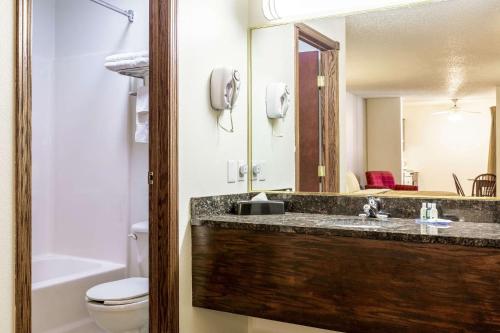 a bathroom with a sink and a toilet and a mirror at Quality Inn Keystone near Mount Rushmore in Keystone