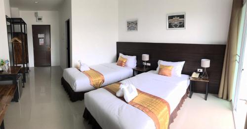 a hotel room with two beds and a desk at P Bliss hotel in Phayao