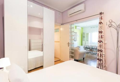 een slaapkamer met een wit bed en een spiegel bij Puerta del Sol Apartament in Madrid