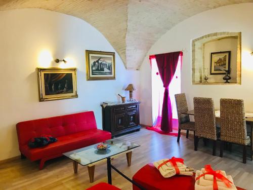 a living room with a red couch and a table at Spello Vacanze Dante's House piano terra in Spello