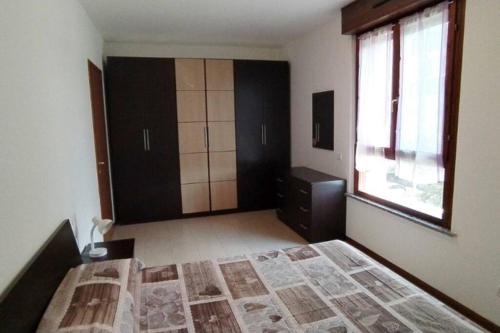 een slaapkamer met een bed, een dressoir en een raam bij LA SISTEMAZIONE BRILLANTINO TITANIUM in Rozzano