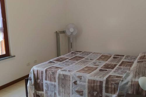 een slaapkamer met een bed met een deken en een ventilator bij LA SISTEMAZIONE BRILLANTINO TITANIUM in Rozzano