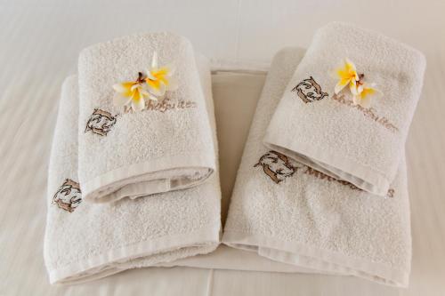 dwa ręczniki na łóżku z kwiatami w obiekcie Mythos Suites Diskos w mieście Lentas