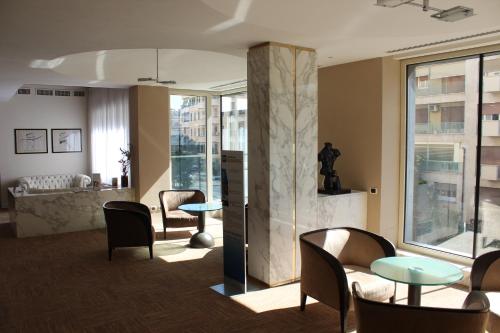 un hall avec des tables et des chaises et un bâtiment dans l'établissement Best Western Hotel Piccadilly, à Rome