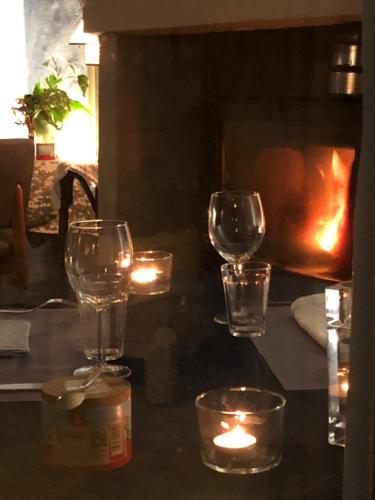 trois verres à vin assis sur une table avec des bougies dans l'établissement La Belle Etoile Chambres, à Roaix