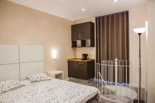 a small bedroom with a bed and a kitchen at Rossio Suites in Lisbon