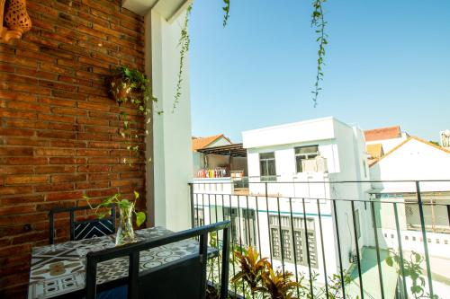 a balcony with a table and a brick wall at HOI AN HEART LODGE in Hoi An