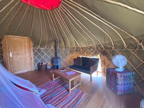 a yurt with a couch and a table in it at Quinta de São José dos Montes in Ferreira do Zêzere