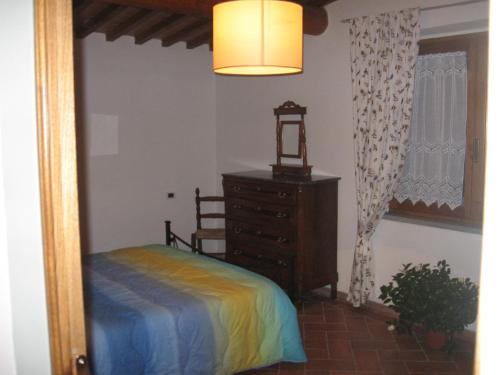 1 dormitorio con cama, tocador y espejo en Agriturismo Le Caselle en Cerbaia