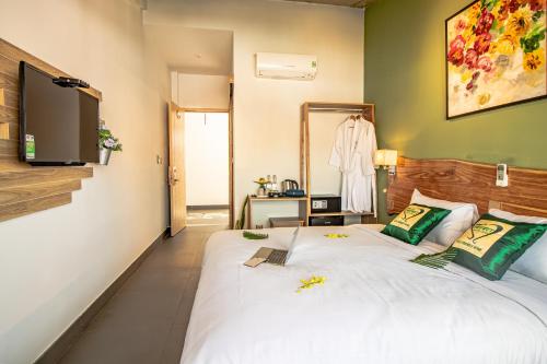 a bedroom with a large white bed and a mirror at HOI AN HEART LODGE in Hoi An