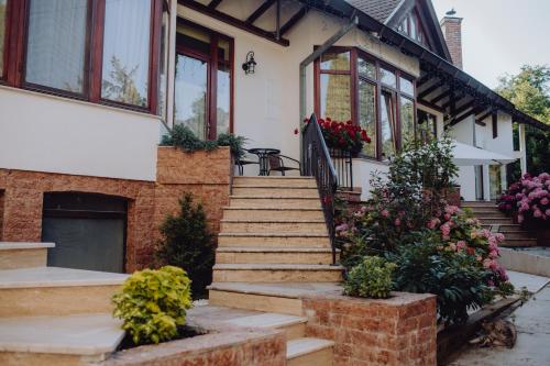 a house with stairs and flowers in front of it at Vila Missy in Deva